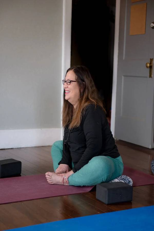 A woman sitting on the ground in a room.