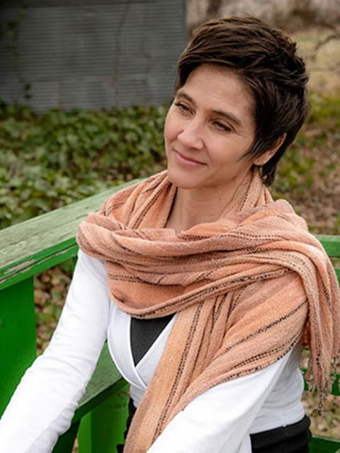 A woman sitting on top of a bench wearing a scarf.