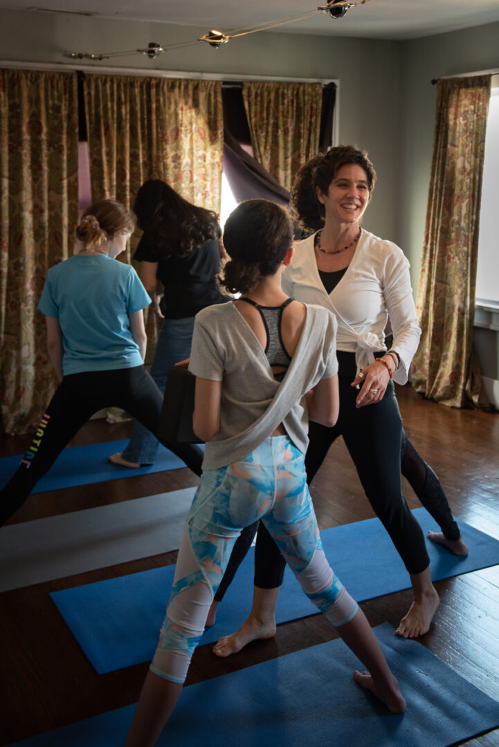 A group of people doing yoga moves in the room.